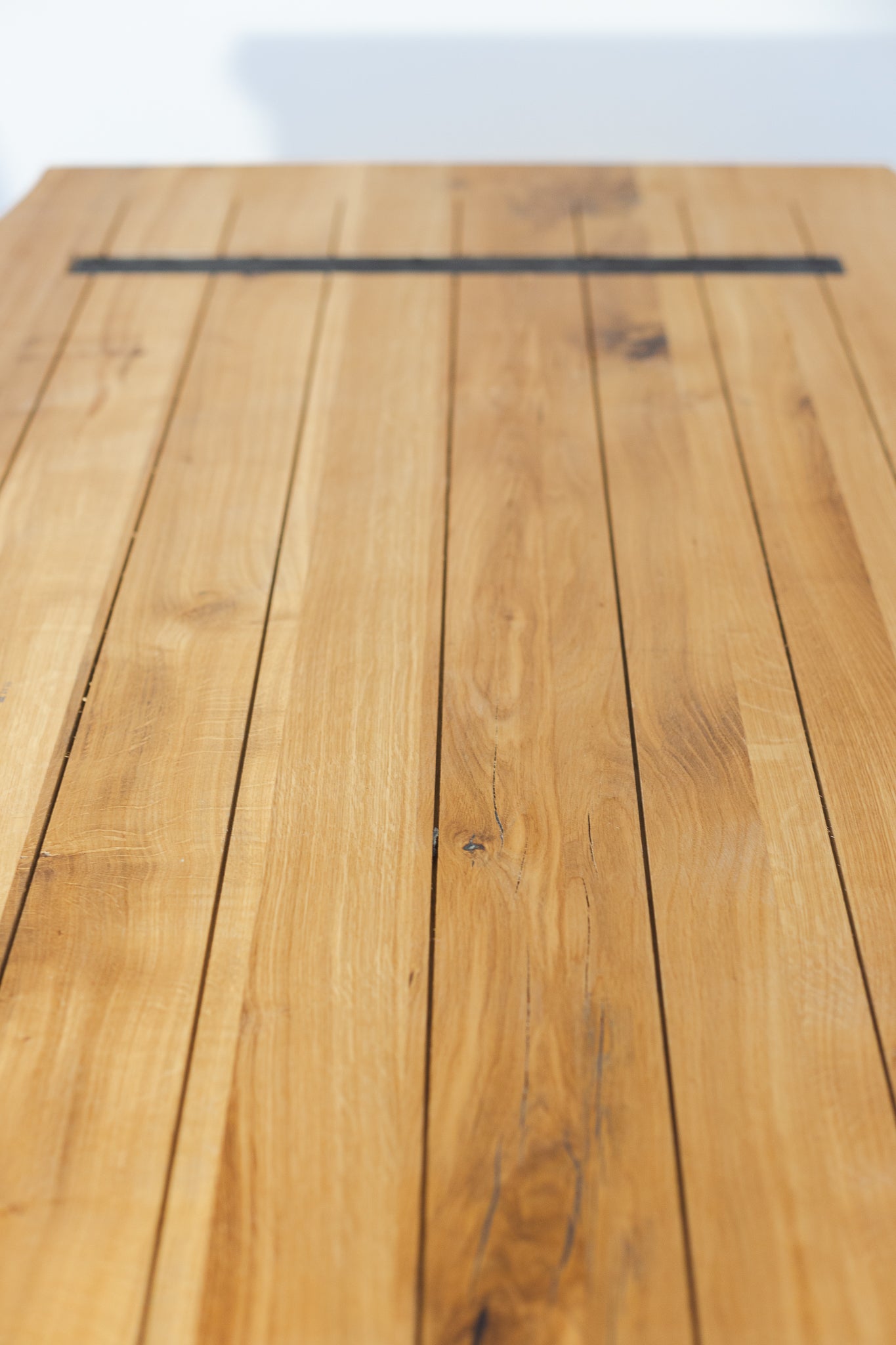 Detailansicht der Unterseite des Esstischs ARBORIS aus Wildeiche, 180x90 cm, mit stabiler Konstruktion, natur geölter Oberfläche und CNC-gefräster Baumkante.